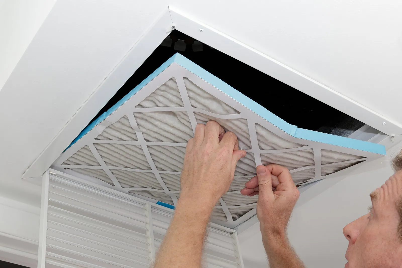 Technician cleaning an air duct vent in a Nocatee home